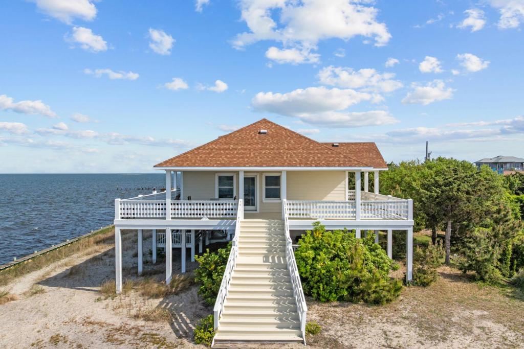 a white house with stairs leading to the ocean at 7659 - Sound Garden in Avon