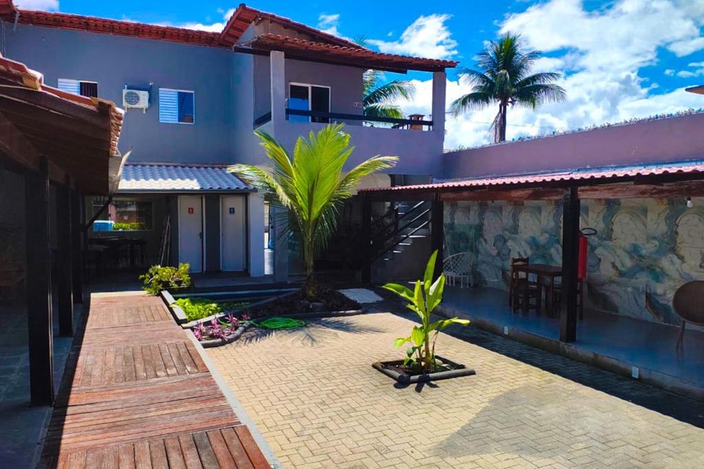 a courtyard of a house with palm trees in it at VELINN Pousada Entre Praias Itaguá in Ubatuba