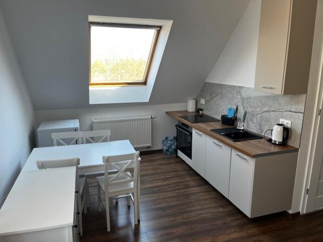 a kitchen with a table and chairs and a window at City Center Szczytno III in Szczytno