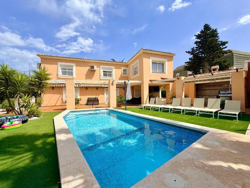 a swimming pool in front of a house at Villa Benidorm Levante Beach Blueline in Benidorm