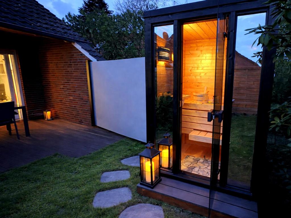 a glass extension to a house with lights in the yard at Sand & Siel Dangast in Dangast