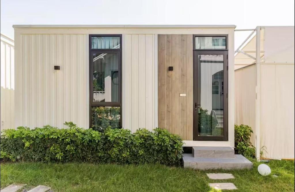 a house with a pivot door in a yard at Coolplay house in Bangkok