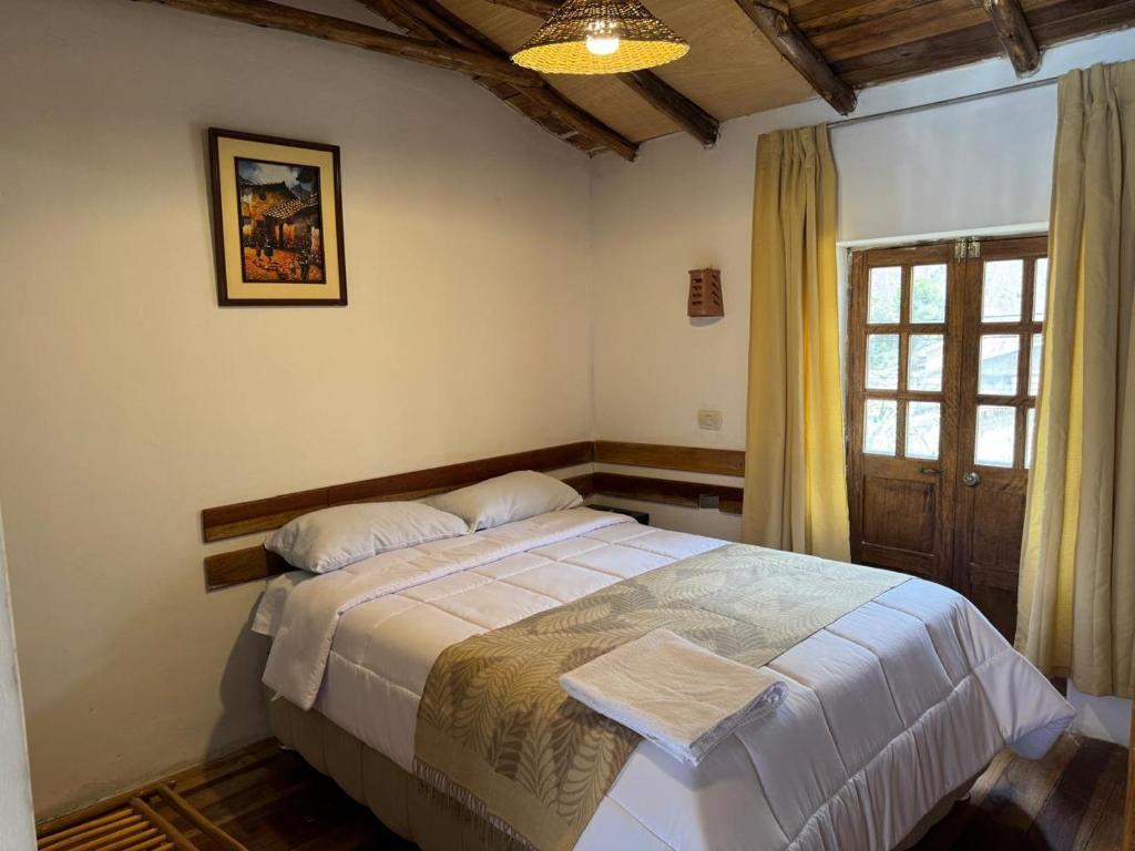 a bedroom with a bed in a room with a window at ollanta lodge in Ollantaytambo