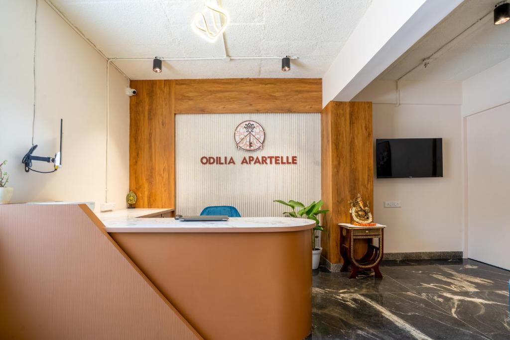 an office with a counter and a sign on the wall at Odilia Apartelle in Bangalore