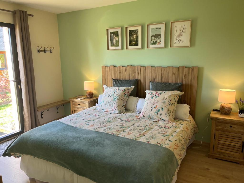 a bedroom with a bed with two night stands and two lamps at Au pré des chants in Saint-Philbert-des-Champs