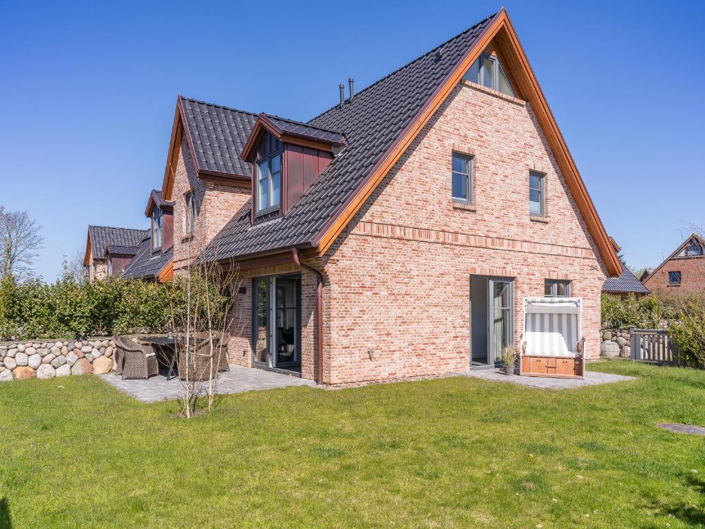a brick house with a gambrel roof at Dorfhüs 1 in Tinnum