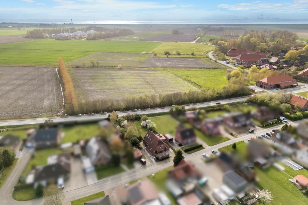 an aerial view of a town with a road and houses at Up Böhn in Krummhörn