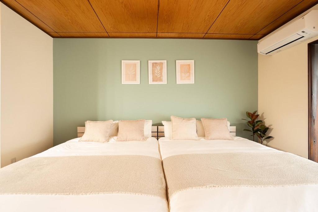 a bedroom with a large bed with white sheets at Staylinks Nara Kitamachi in Nara
