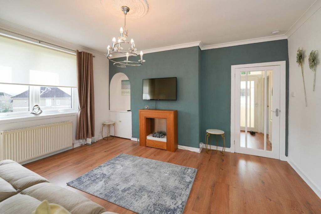 a living room with a couch and a tv at Goldie Apartment 2BR flat in Dalry