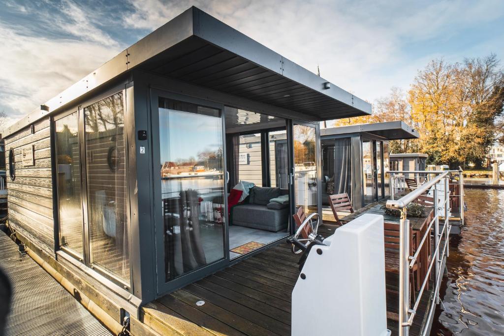 a small house on a boat on the water at Rode Houseboat Zwartsluis in Zwartsluis