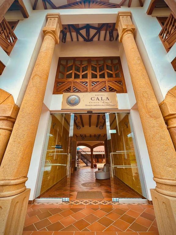an entrance to a building with two columns at Hotel Cala in Cucaita