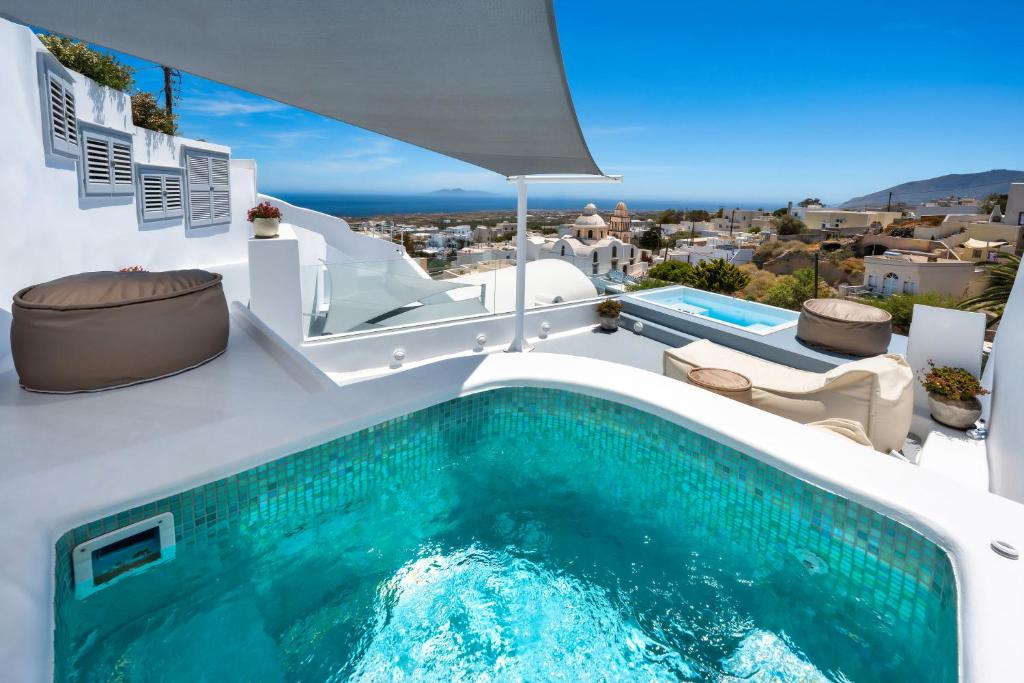 a swimming pool on the side of a villa at Hill Suites in Fira