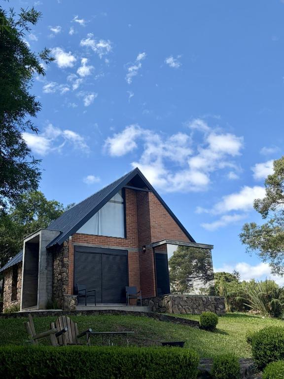 a brick house with a large garage at Guest house Etérea in Flores da Cunha