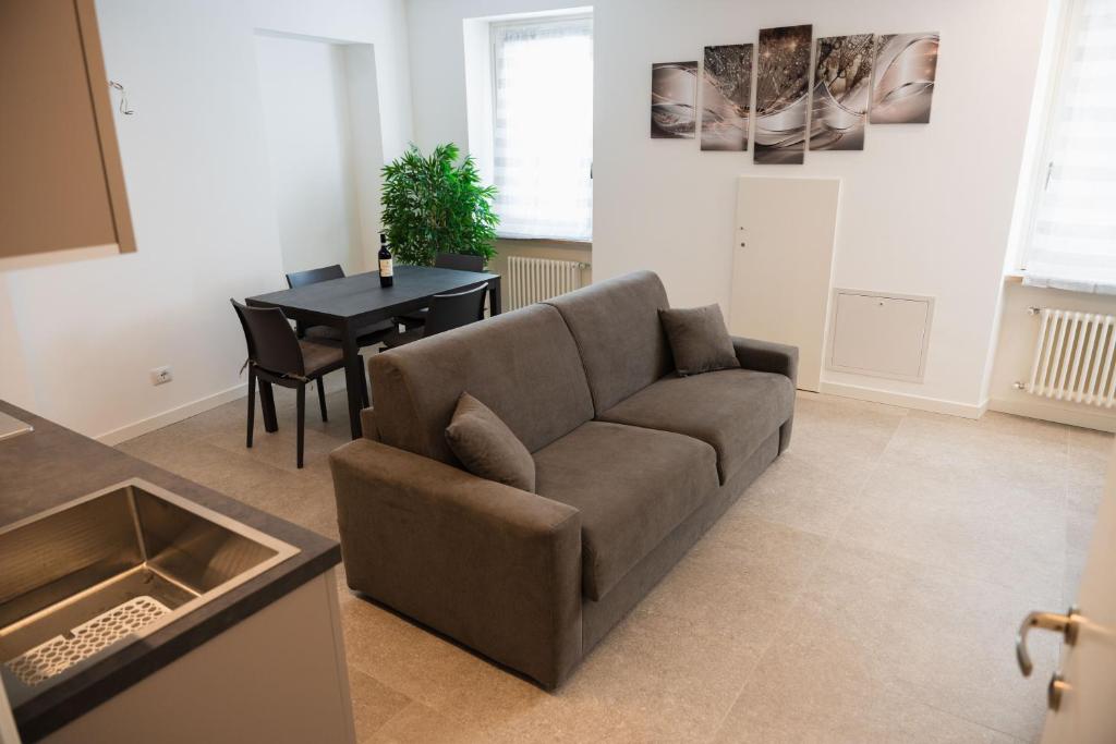 a living room with a couch and a table at Suite Prestige Apartment in Torri del Benaco