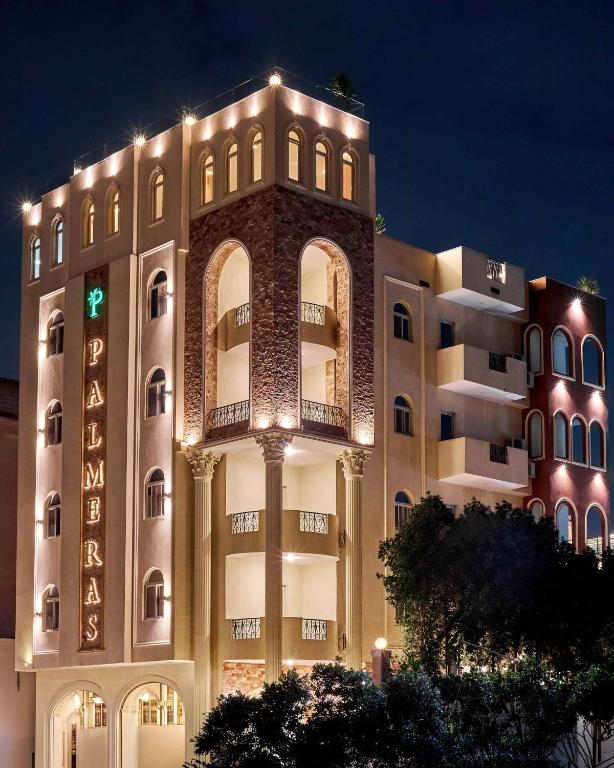a large building with lights on it at night at Palmeras Pyramids Hotel in Cairo