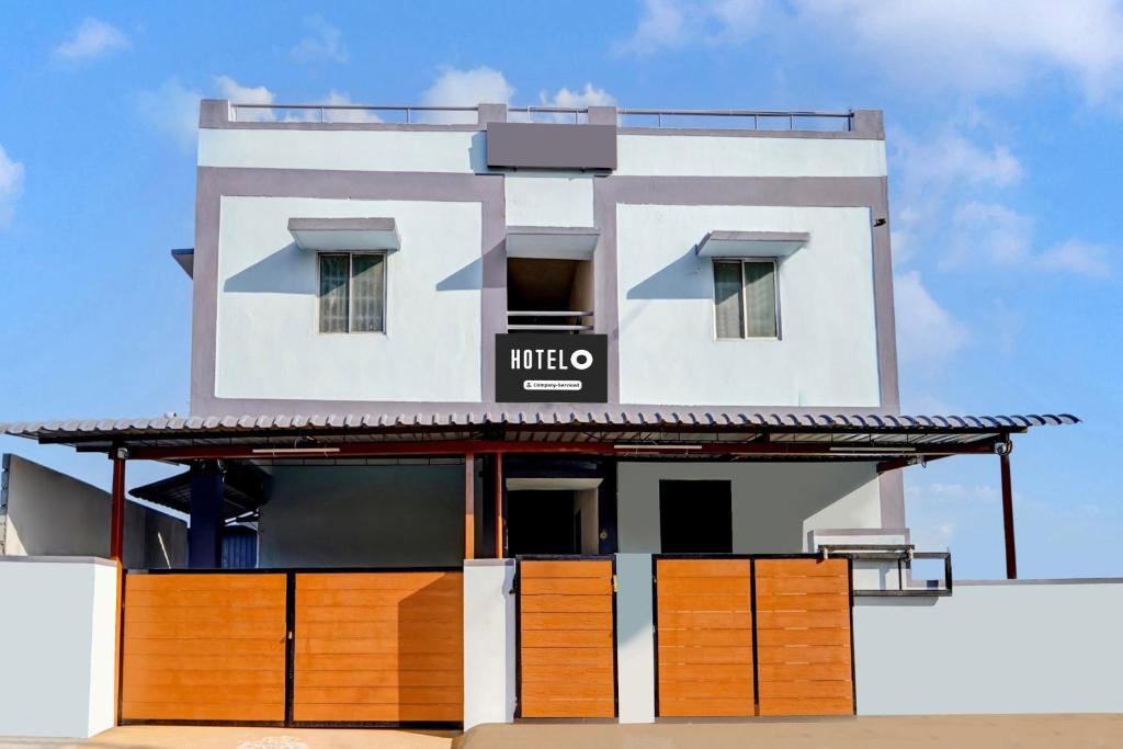 a white building with a sign on it at Super Hotel O Okkilipalayam in Coimbatore