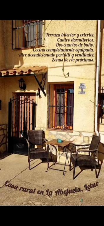 two chairs and a table in front of a building at Casa Rural La Abejuela in Abejuela