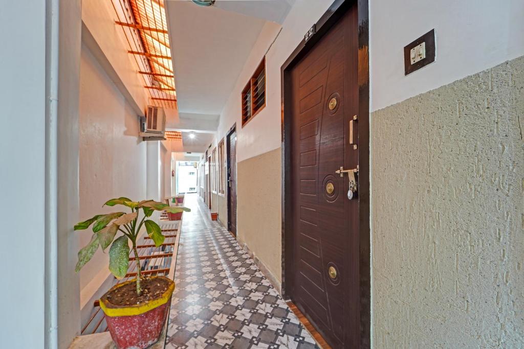 a hallway with a door and a potted plant at Super Hotel O Erode Bus Stand in Erode
