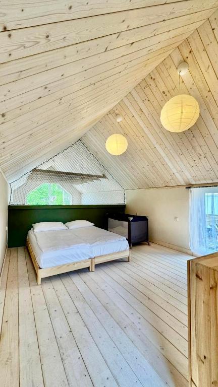 a bedroom with a bed in a wooden ceiling at Stodoła Dębki in Dębki