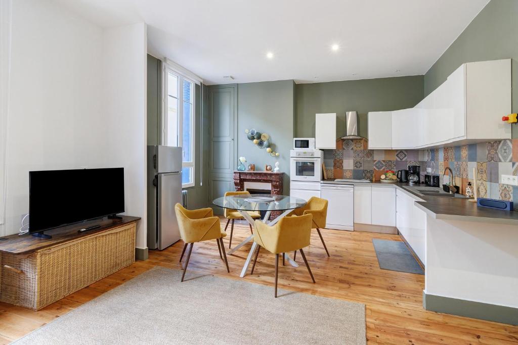 a kitchen with a table and chairs and a television at Trois Clés Apartment 2 - 2 bed in Eymet