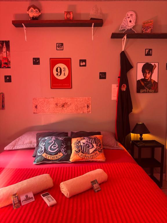 a bedroom with a red bed with pillows on it at Suíte Harry Potter - Pousada Castelo do Luar in Penha