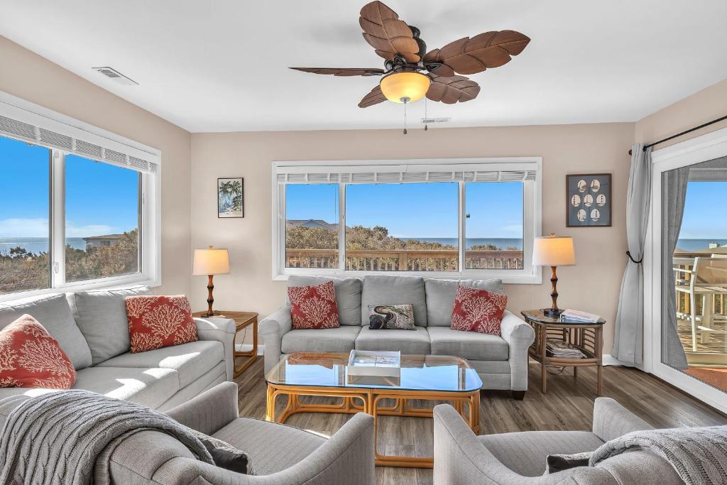 a living room with couches and a ceiling fan at Sea-Nic View by Oak Island Accommodations in Caswell Beach