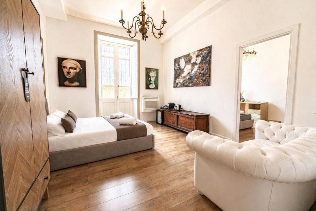 a bedroom with a bed and a couch and a chair at Sa Costixedda Rooms in Cagliari