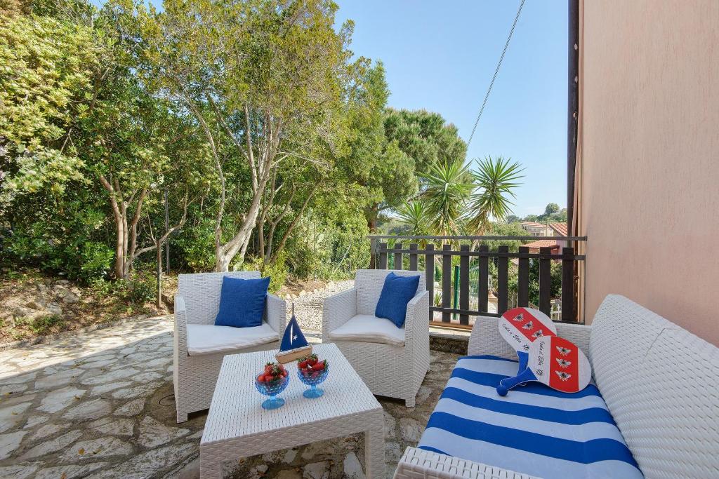 a patio with two white chairs and a table and sidx sidx sidx at Apartment Celeste - Isola D'elba in Portoferraio
