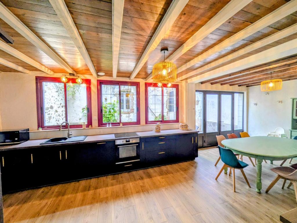 a kitchen with a table and a dining room at Laroseliere in Mauléon