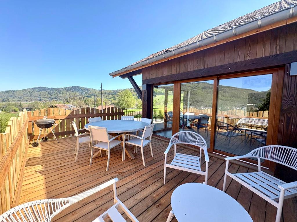 a wooden deck with tables and chairs on it at Gîte d'Eléonore in Rupt-sur-Moselle