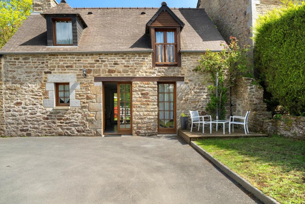 a stone house with a table and chairs in the driveway at Maison - Le Clos Des Pommiers in Pleudihen-sur-Rance