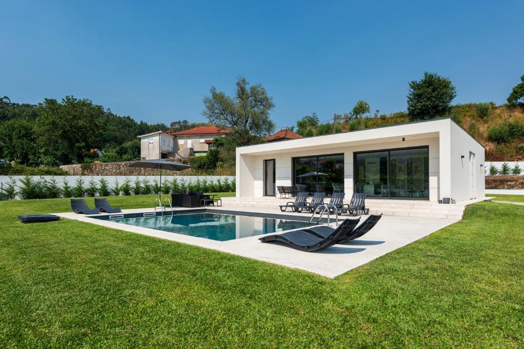 a house with a swimming pool in a yard at Casinha da Ribeira in Vila Verde
