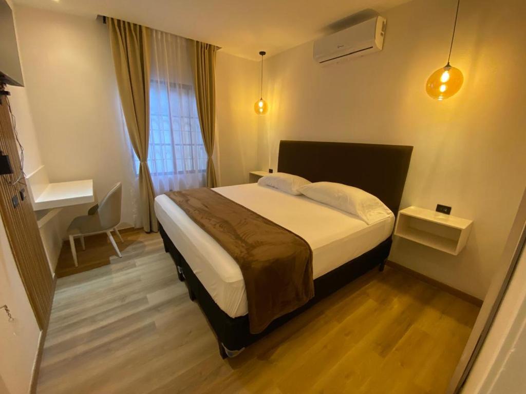 a bedroom with a bed and a desk in it at Hotel Merendón Express in San Pedro Sula
