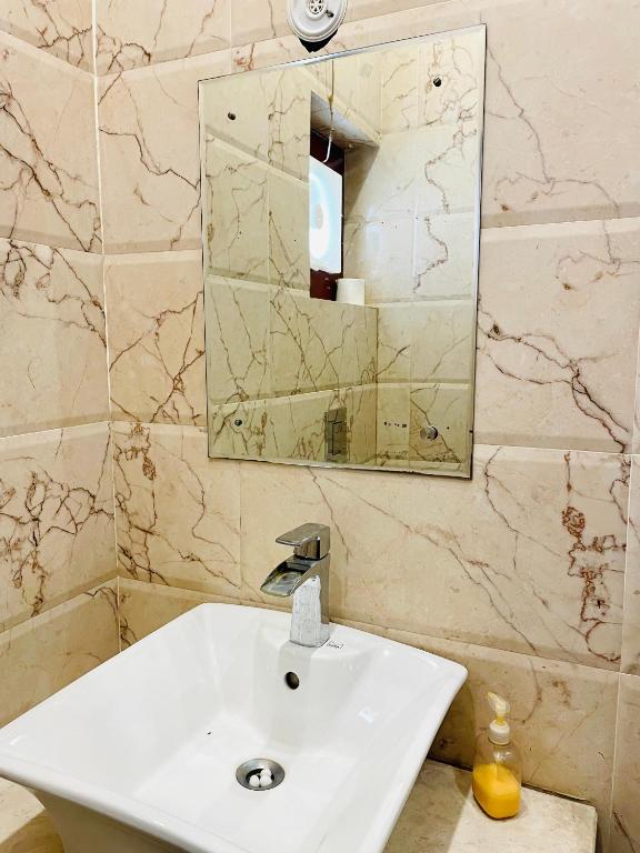 ein Badezimmer mit einem weißen Waschbecken und einem Spiegel in der Unterkunft MBH hotel in Tatārsar