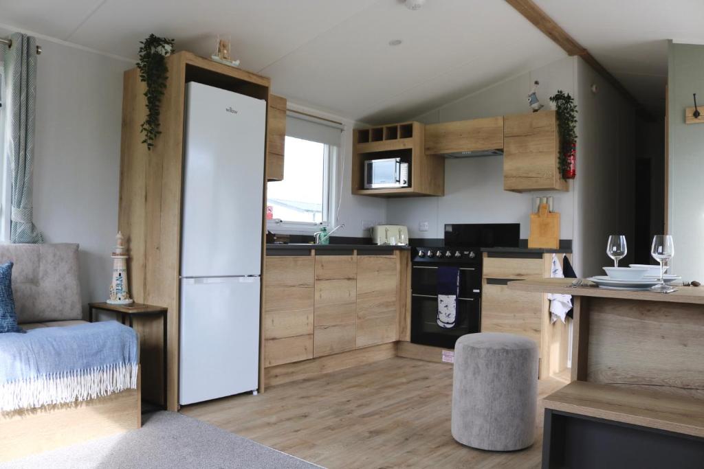 a kitchen with a white refrigerator and a counter at Saltwinds - Camber Sands in Camber