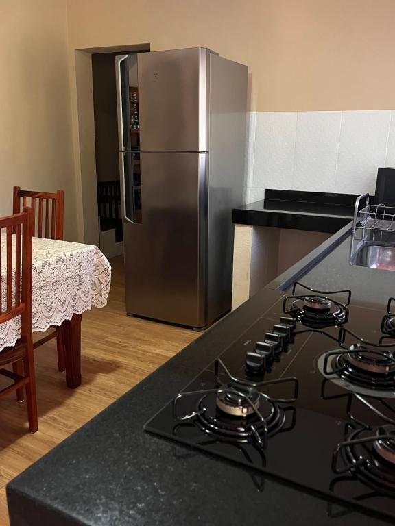 a kitchen with a stove and a stainless steel refrigerator at Casa Por Do Sol in Paraty