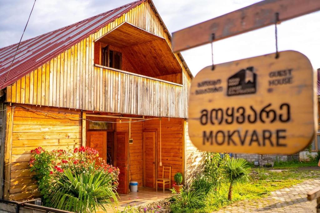 a wooden house with a sign in front of it at Guest House Mokvare in Gundauri