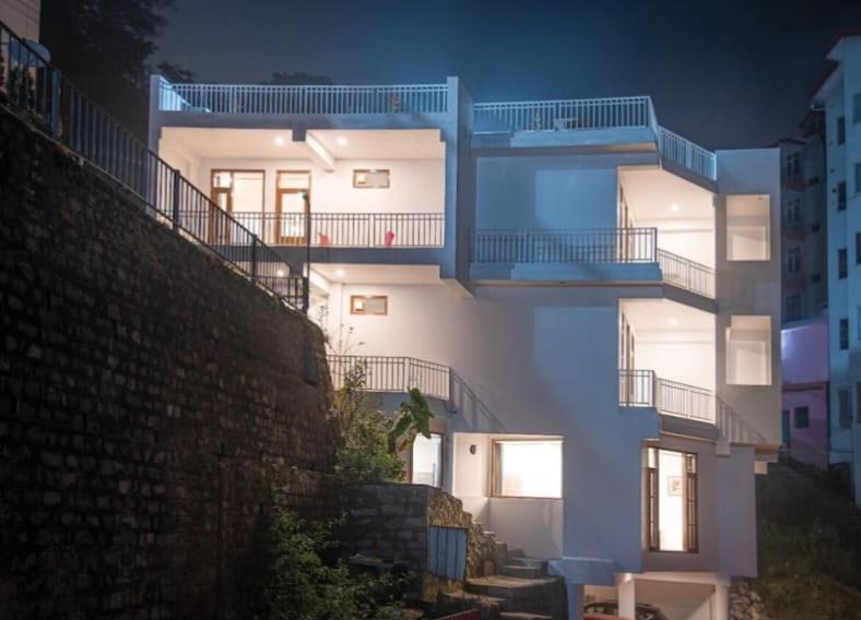a large white building with blue balconies on it at Silver Crest Hotel Kasauli in Kasauli