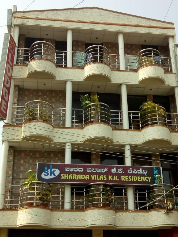 a building with a sign on the side of it at Sharada KK Residency in Mysore