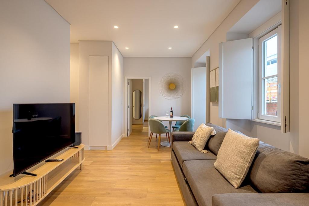 a living room with a couch and a flat screen tv at CapeTown Marula 1BR apartment in Caparica