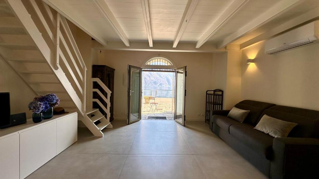 a living room with a couch and a large window at Appartamento Zu fronte lago con piscina in Fonteno