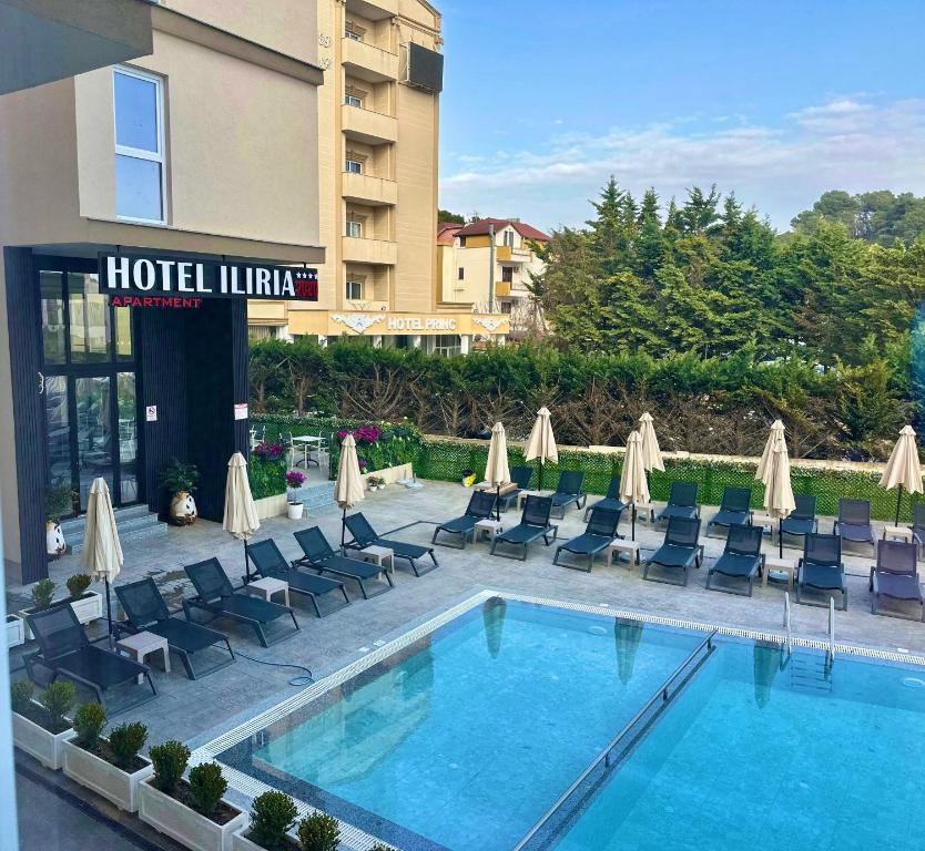 a hotel with a pool and chairs and a building at Hotel Iliria in Golem
