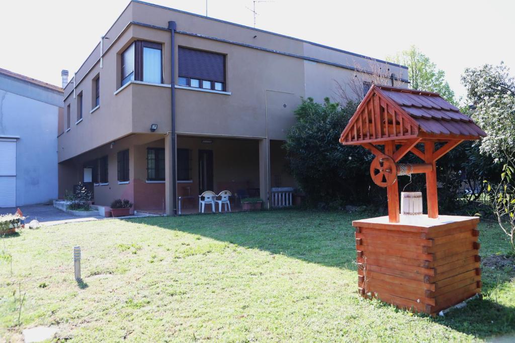 a house with a wooden structure in the yard at KapaCasa in Villanova