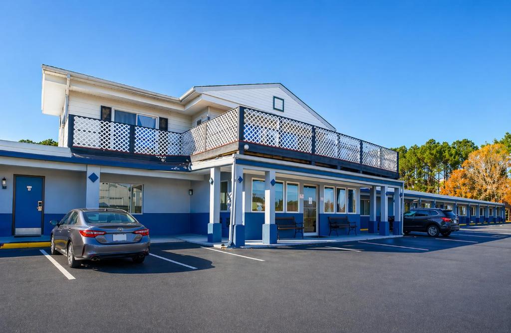a building with a car parked in a parking lot at Whispering Pines by Hotel O White stone VA in White Stone