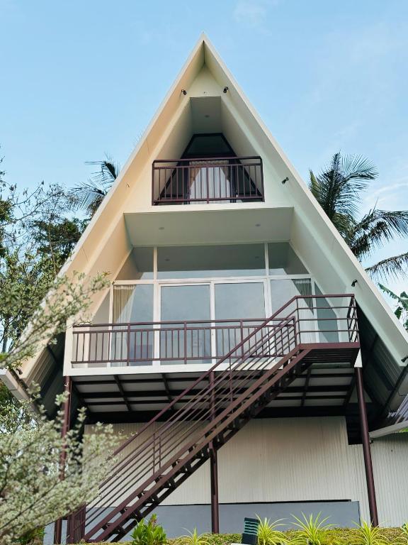a building with a staircase and a balcony at Wilmora in Ramakkalmedu