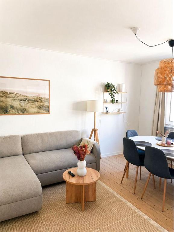 a living room with a couch and a table at Hyggelig, lys og centralt lejlighed in Esbjerg