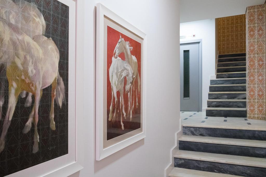 un pasillo con obras de arte en la pared y escaleras en Simon Guest Apartments, en Oporto