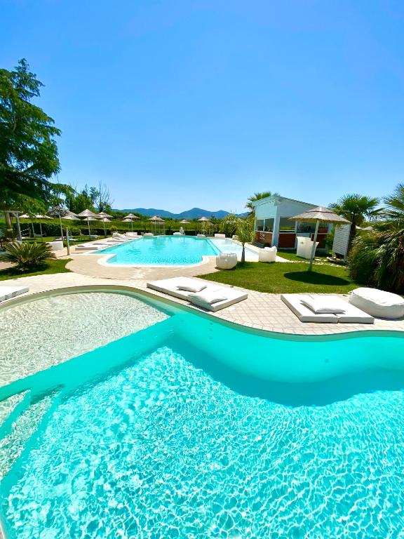 ein großer Swimmingpool mit Liegestühlen in einem Ferienresort in der Unterkunft La Siègià Resort spa in Massa Marittima
