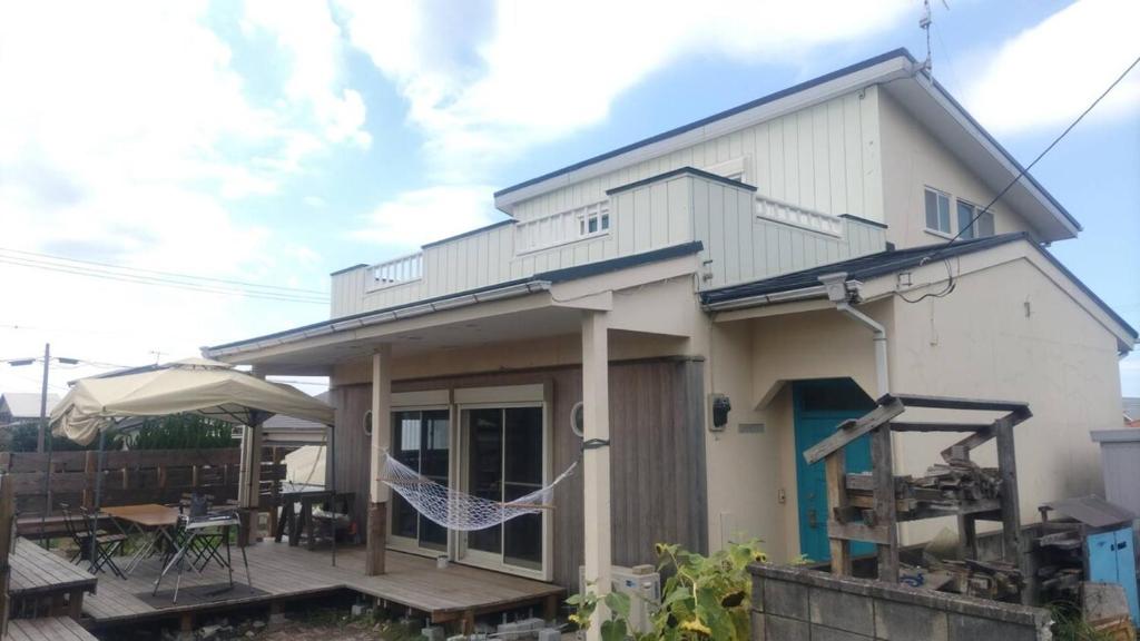 a house with a hammock in front of it at K'sVILLAGE 平砂浦ハウスＳ in Tateyama