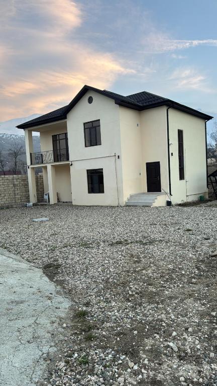 a white house sitting on top of a gravel lot at house for daily rent in Laza